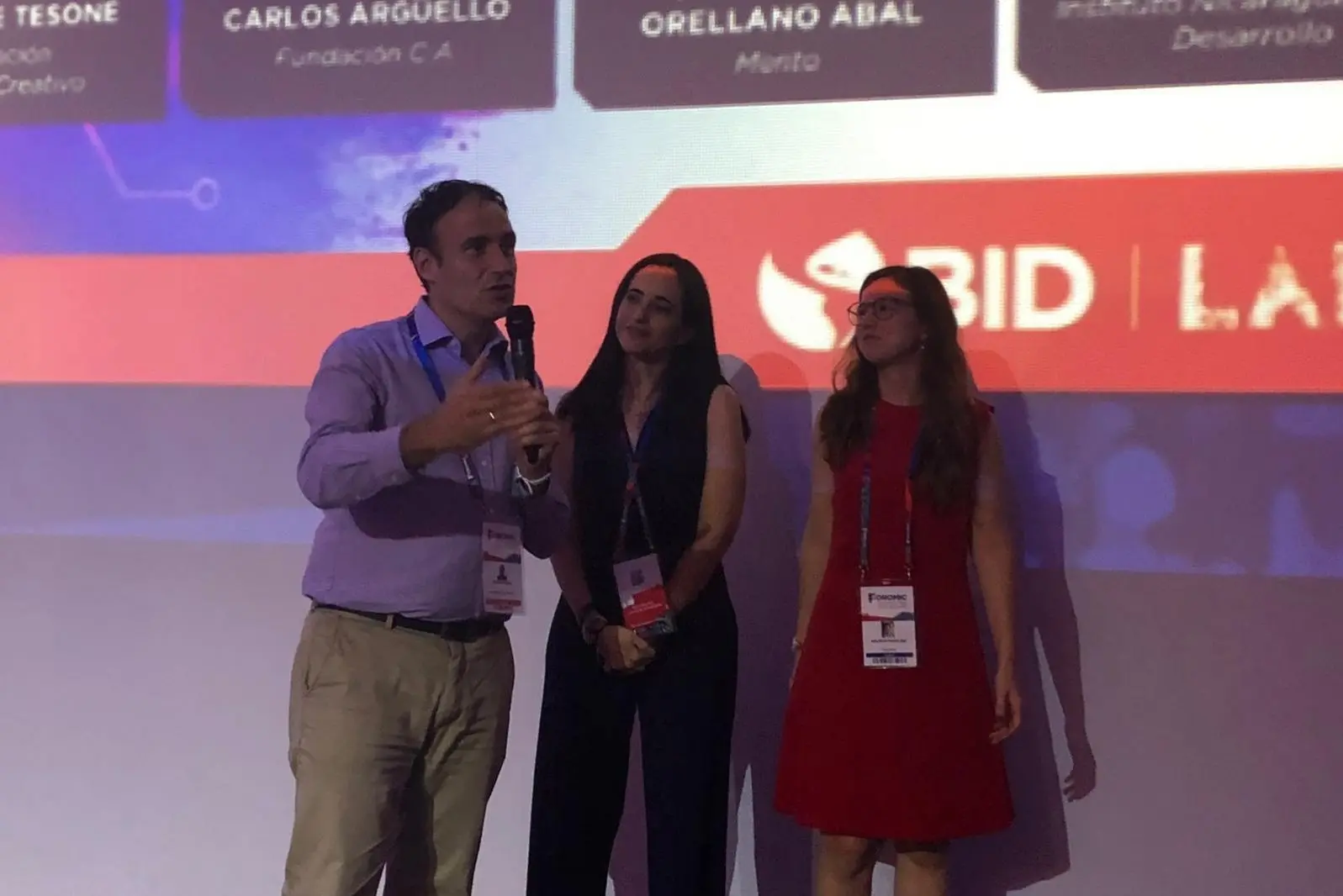 Portrait of a woman with brown hair on a flat gray background.