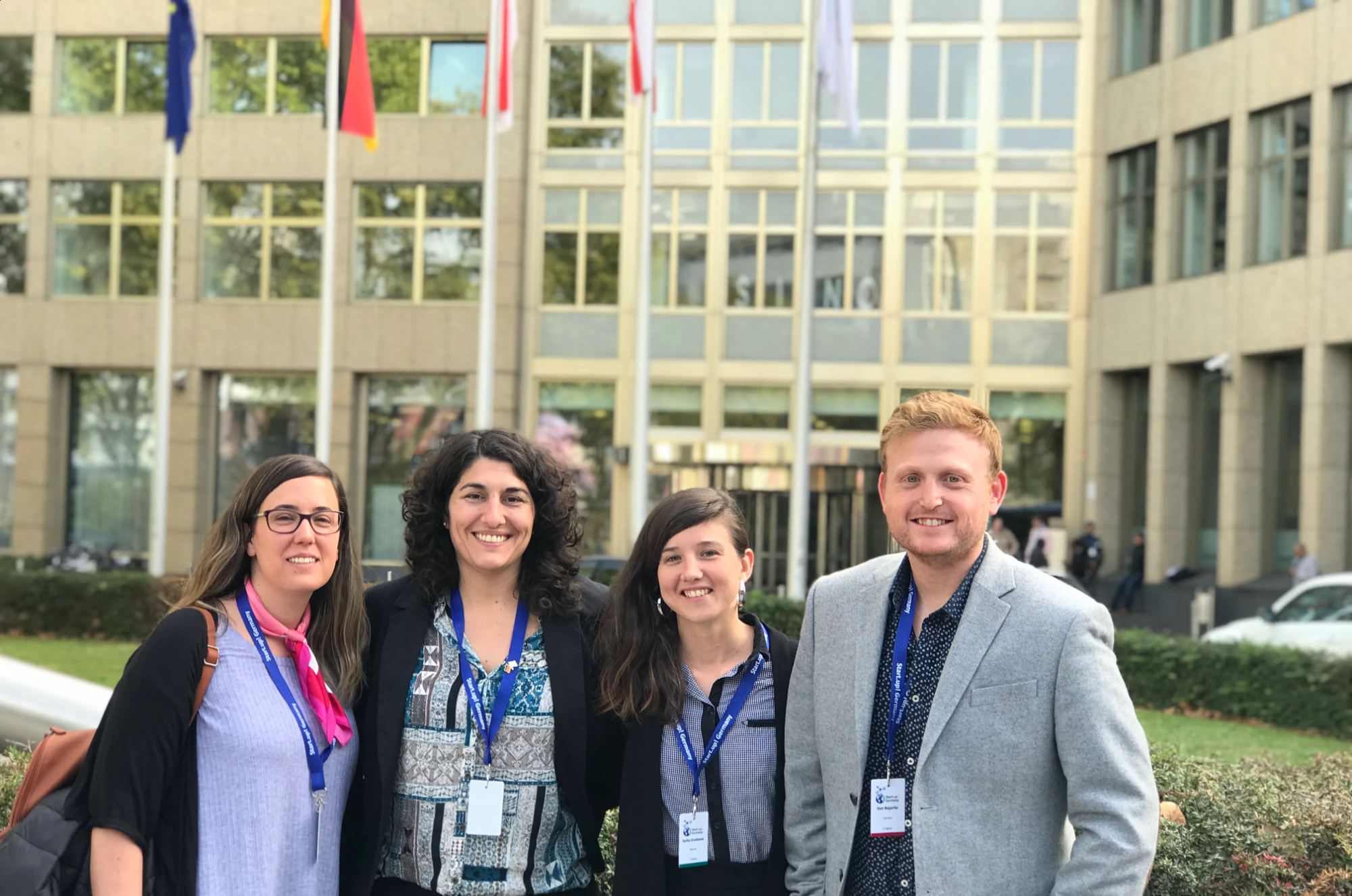 Portrait of a man with brown hair and glasses on a flat gray background.
